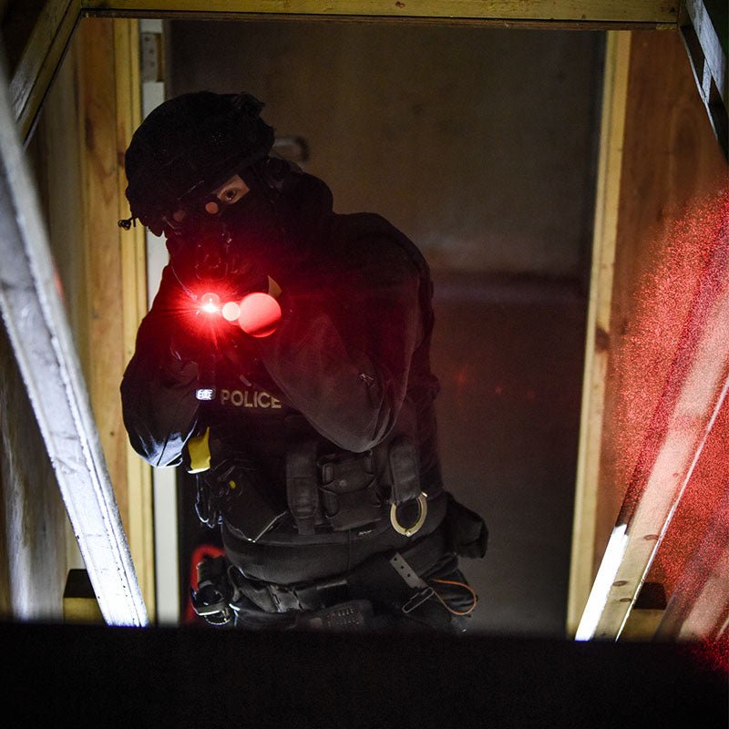 Police officer clearing a doorway using the red aiming laser of the ProTac Rail Mount HL-X Laser