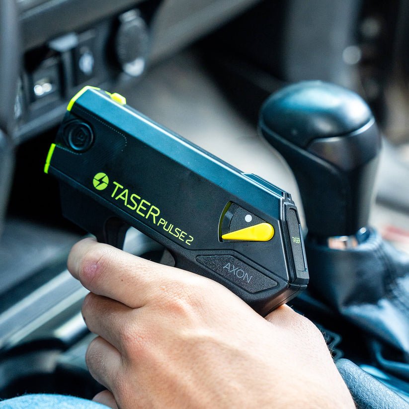 A hand holding a Taser Pulse 2