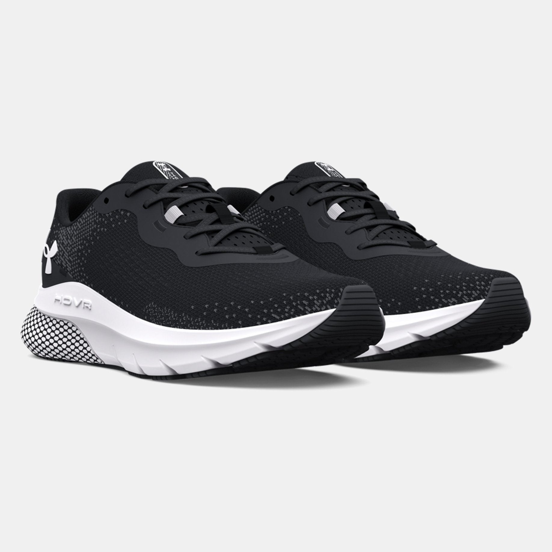 Black running shoes with white soles on a light gray background