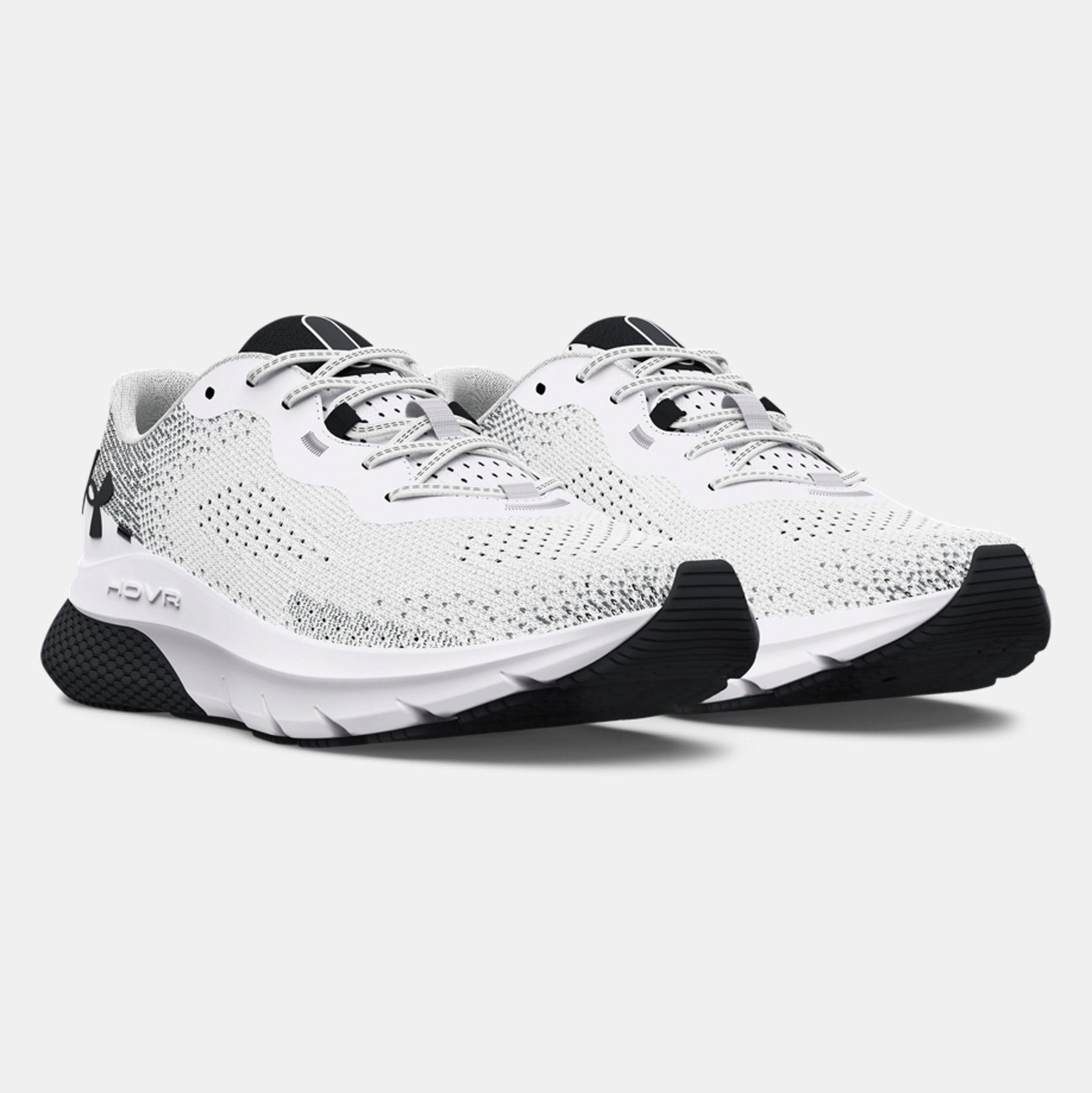 White running shoes with black soles on a light gray background