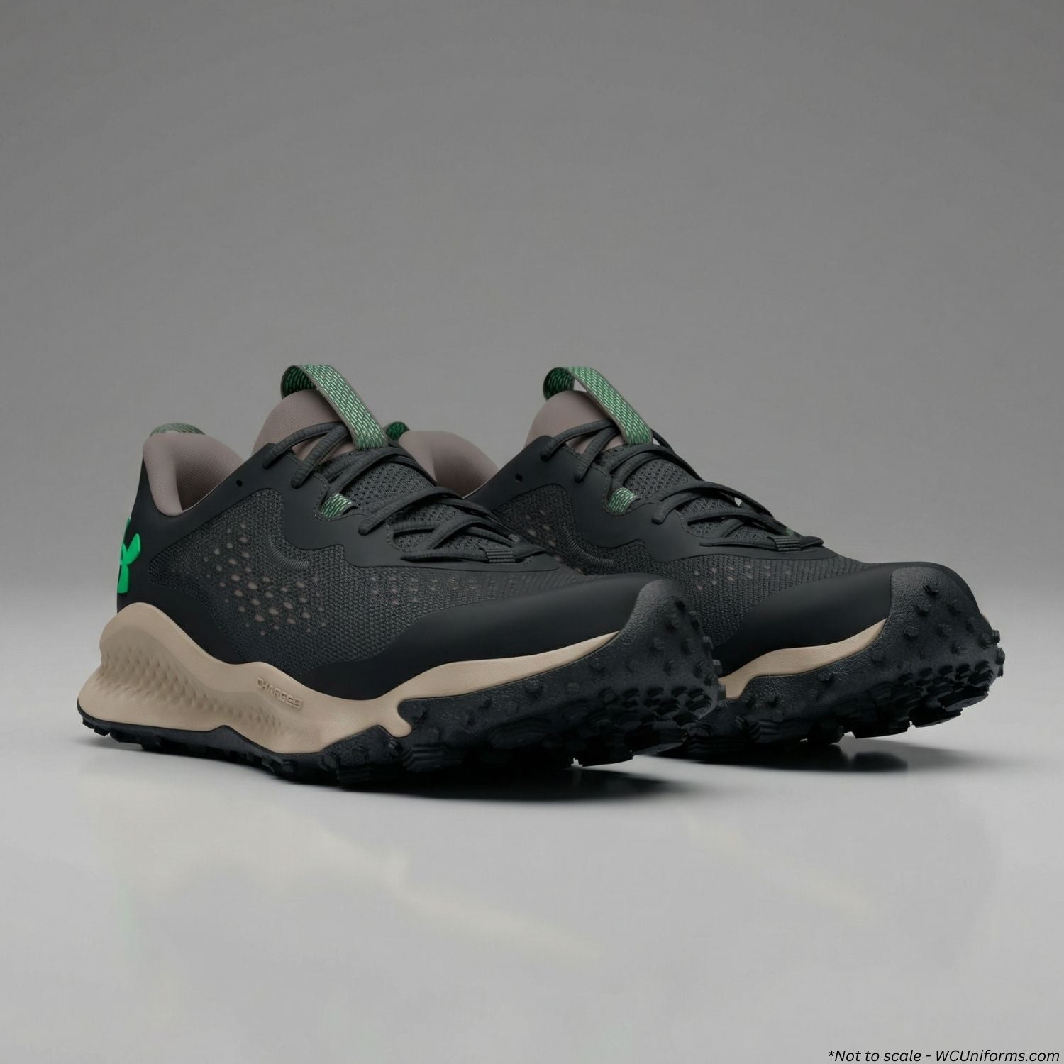 Black and beige hiking shoes with green accents on a gray background