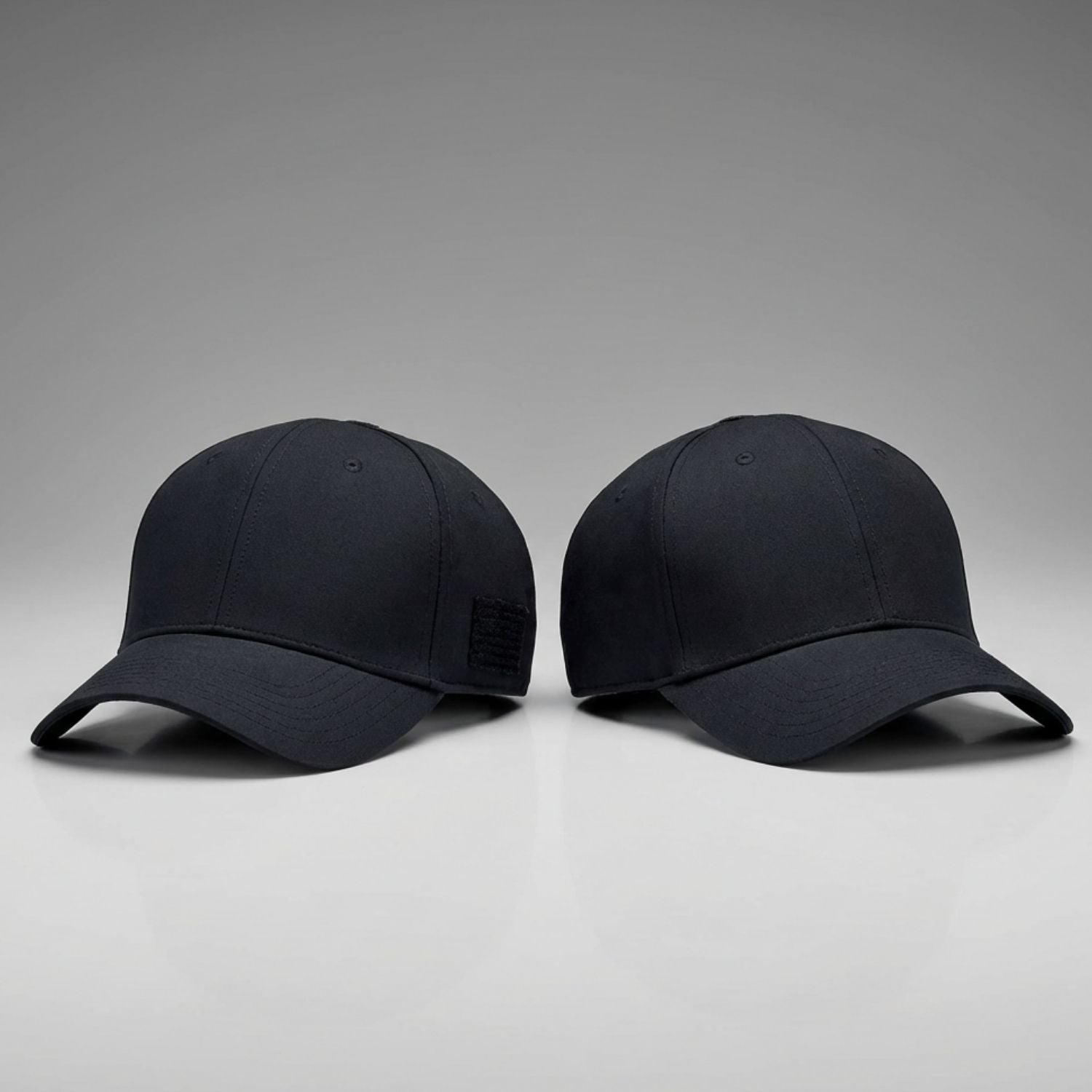 One black and one dark navy blue baseball cap on a gray background