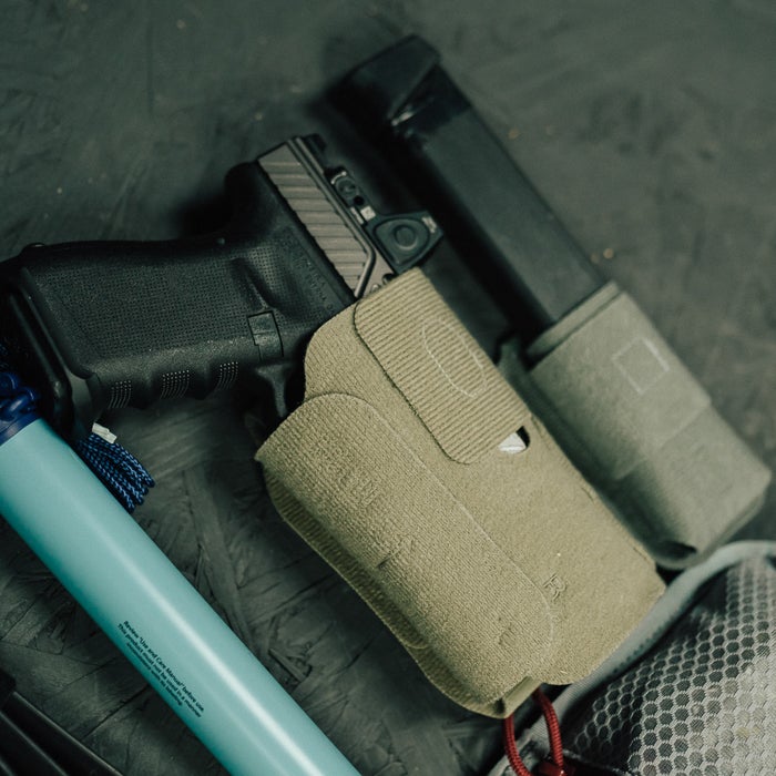Close-up of a gun holster with a magazine on a textured surface