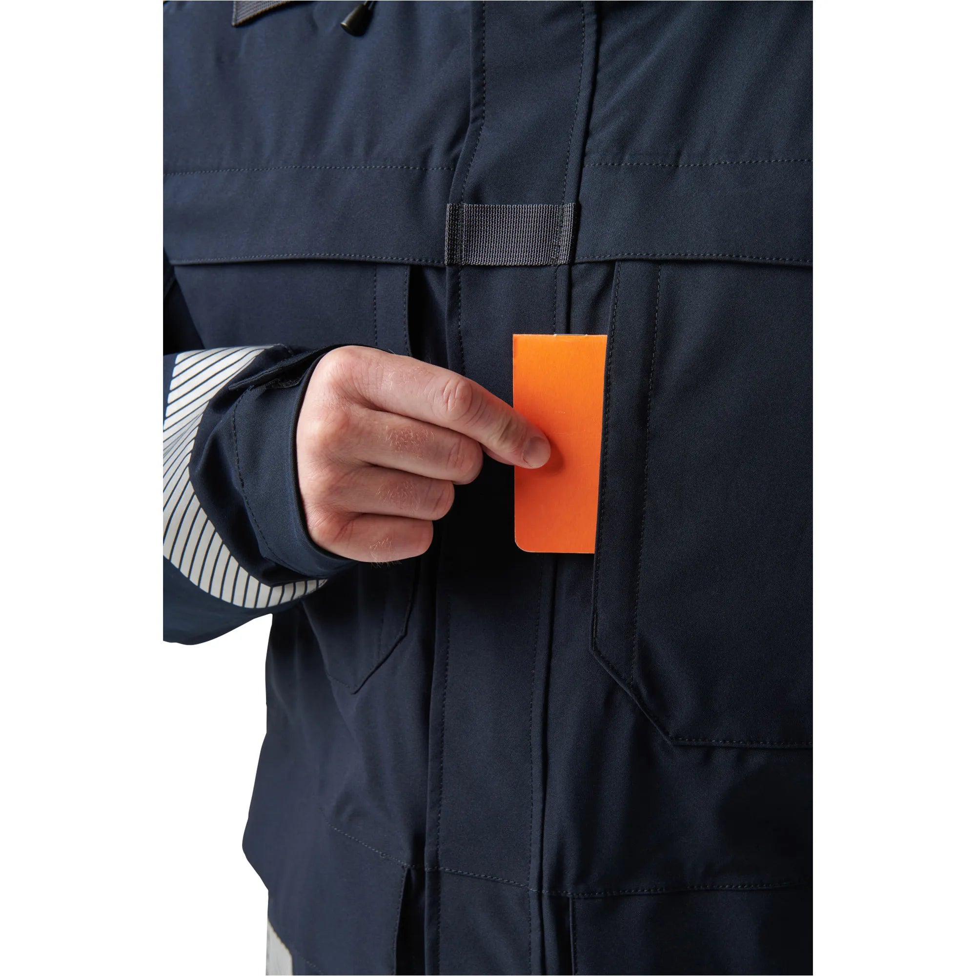 User inserting a card into the chest pocket of the 5.11 Tactical Responder Parka 2.0, showcasing its practical design and convenience.