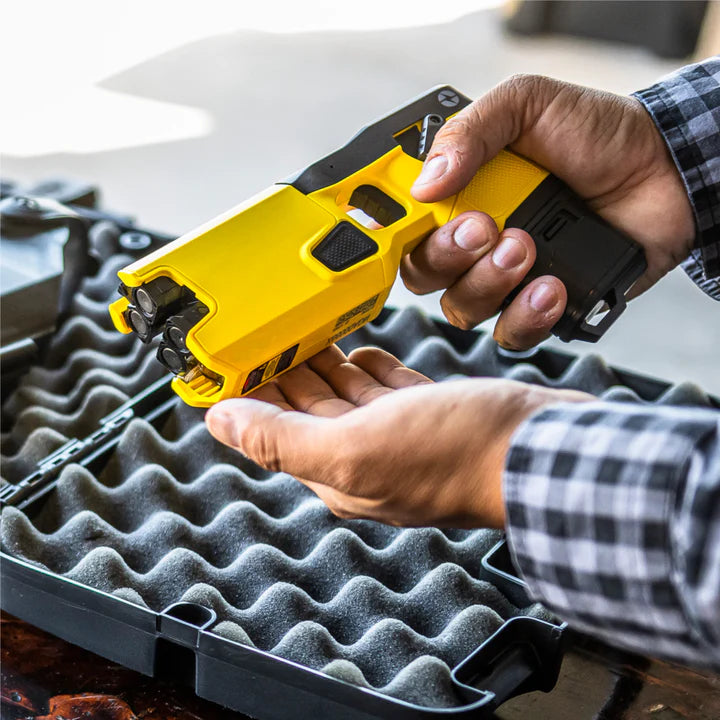 Man inspecting a TASER 7 CQ Home Defense – 12‑Foot range double‑shot stun device with laser and contact‑stun mode 20285 - Taser CEW's