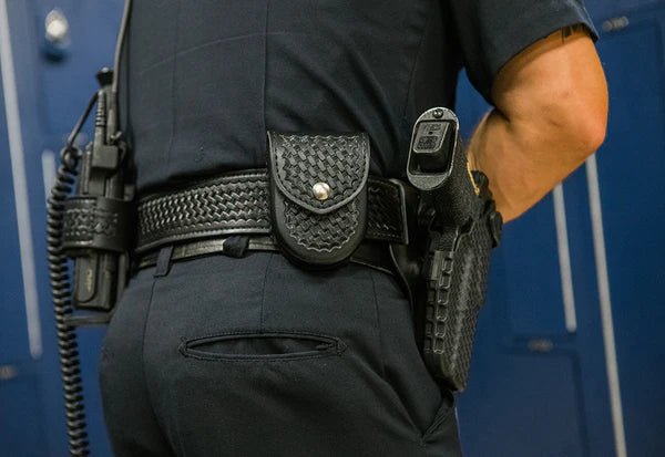 Safariland Model 7917 black basketweave double handcuff case with chrome snap worn on an officer's duty belt.